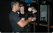 A man holding a rifle while another man gives him instructions